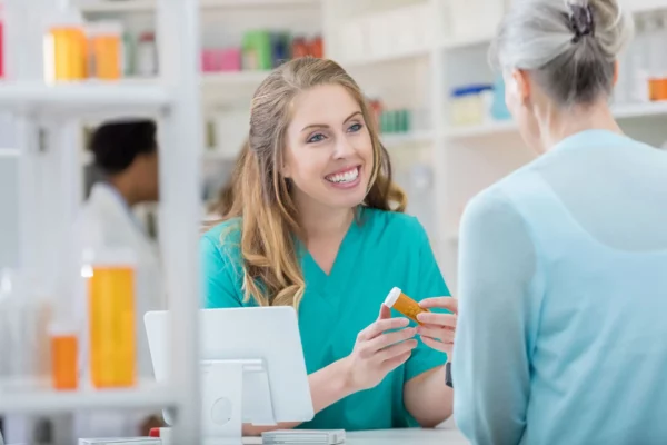 pharmacy tech helping out old lady at the counter