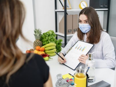 dietitian holding diet plan during consultation with patient in the office